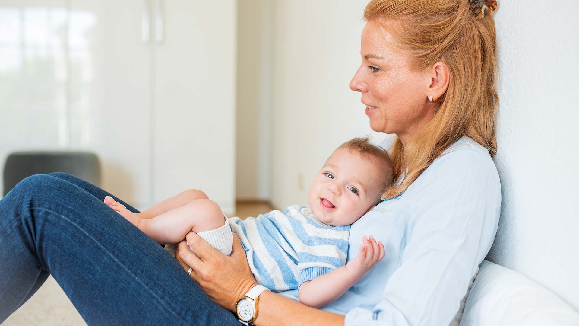 Baby auf dem Arm einer jungen Frau